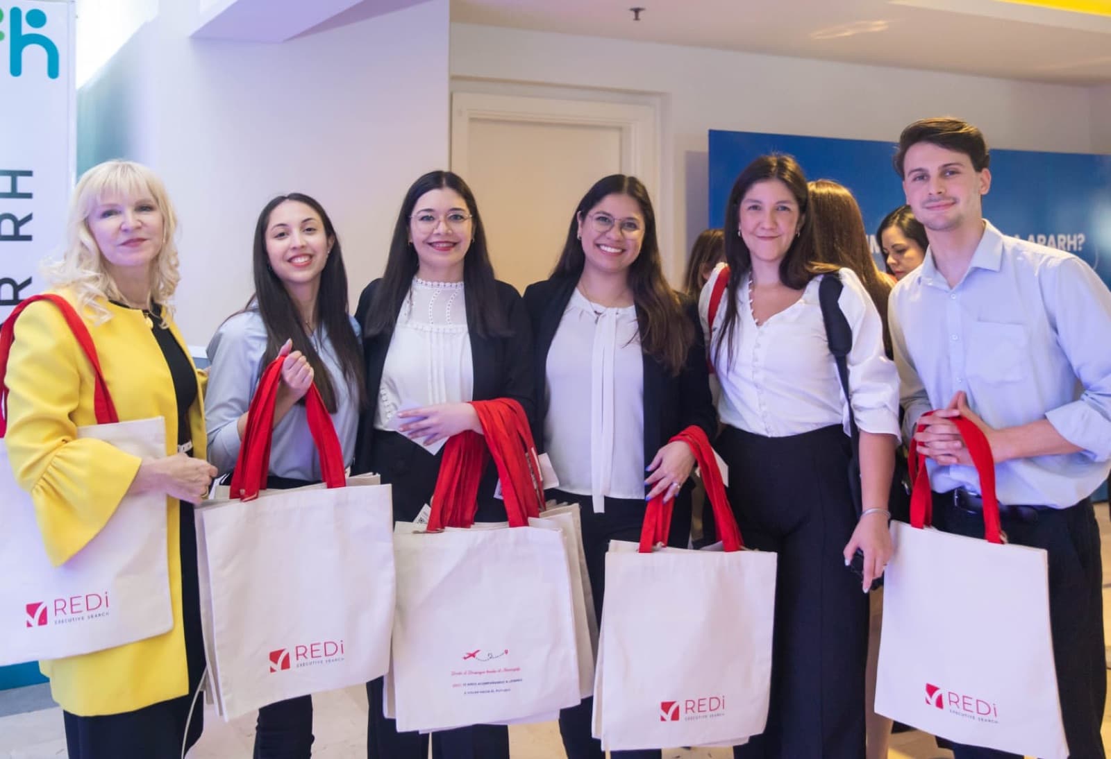 Integrantes de REDi con bolsas de la marca en un encuentro de recursos humanos